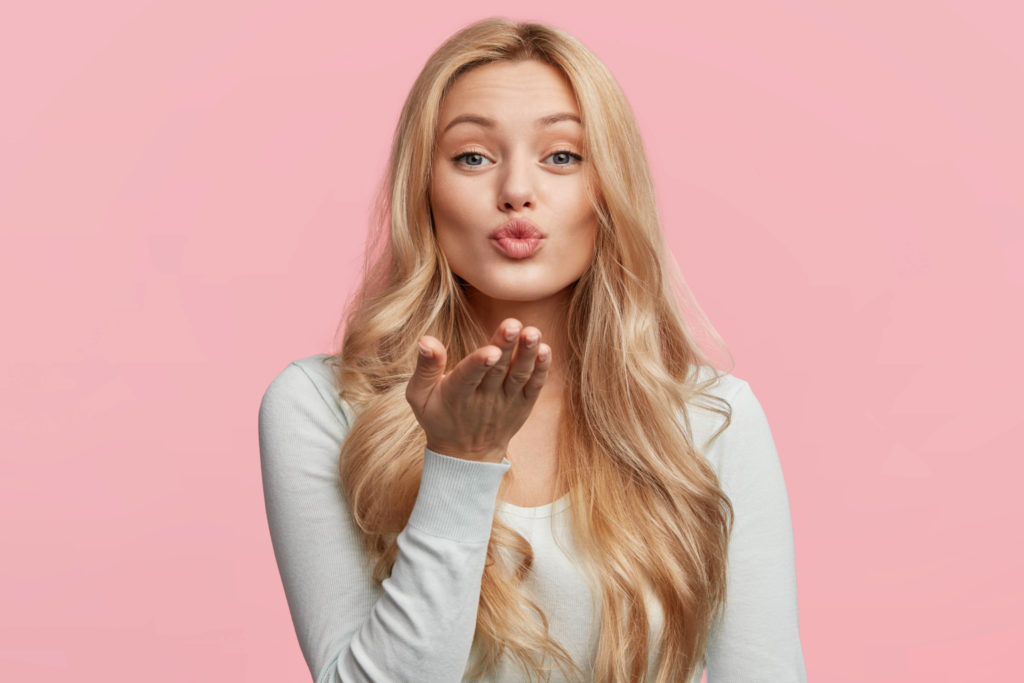 blonde woman blowing a kiss