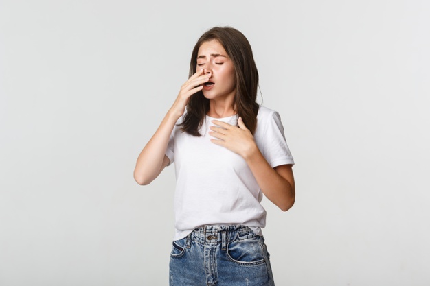 a young woman sneezing